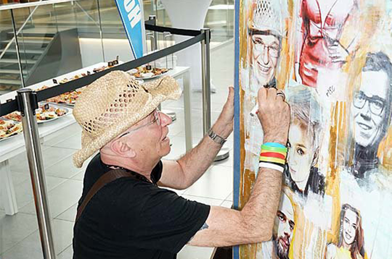 Ein Prominenter aus Hamburg signiert sein Porträt auf Leinwand