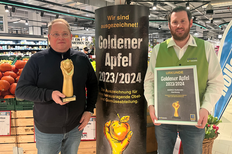 Marktinhaber Kay Hollender (links) und Marktleiter Björn Behncke präsentieren die Trophäe und die Urkunde, die EDEKA Hollender im Krohnstieg Center im Rahmen der Auszeichnung "Goldener Apfel" 2024 erhielt