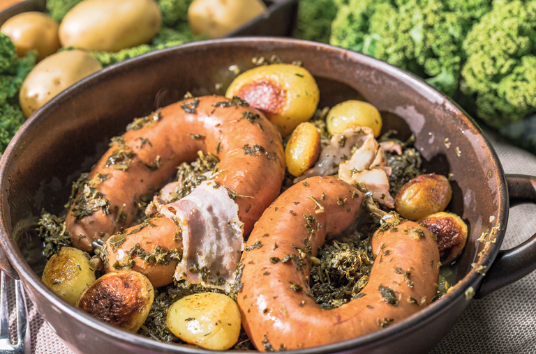 Eine frisch zubereitete Pfanne Grünkohl mit Pinkel und Kartoffeln